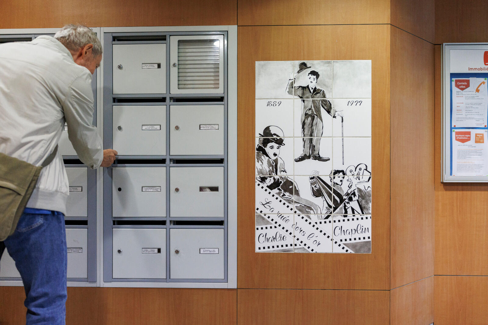 Dans un immeuble une personne ouvre sa boîte à lettres